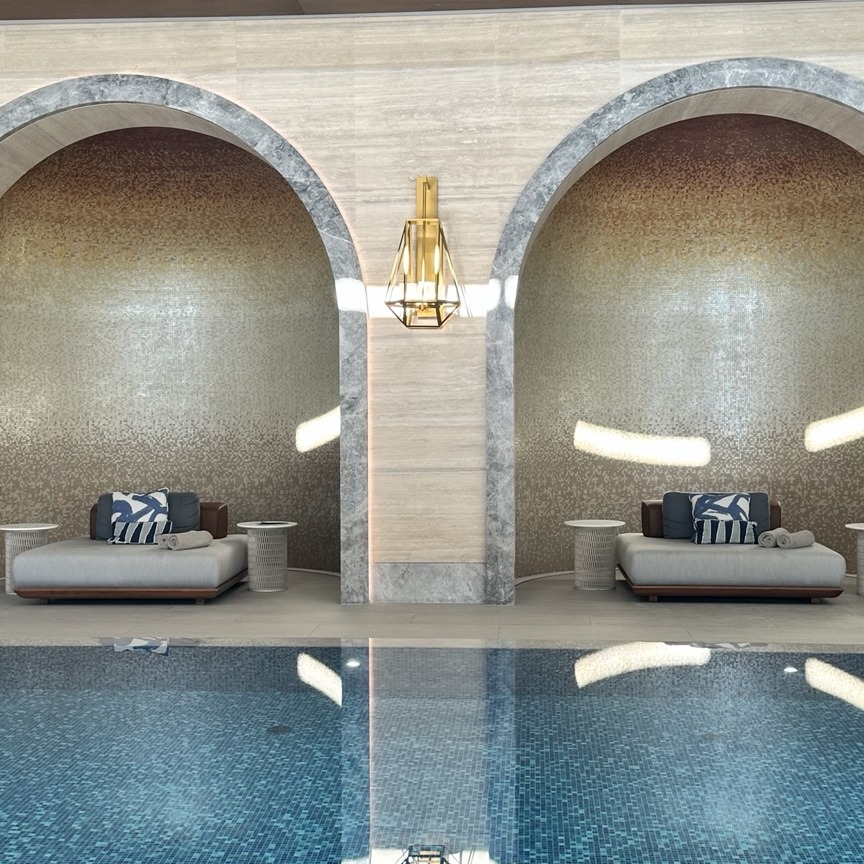 An architectural indoor wellness pool with arched alcoves